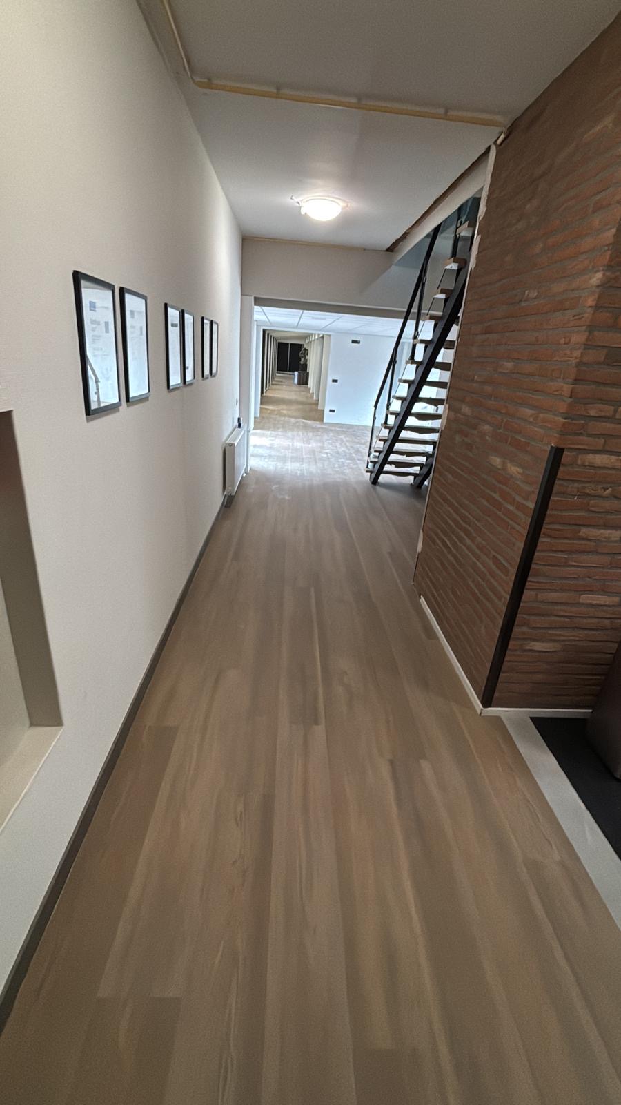 Gang met PVC-vloer en stenen wand