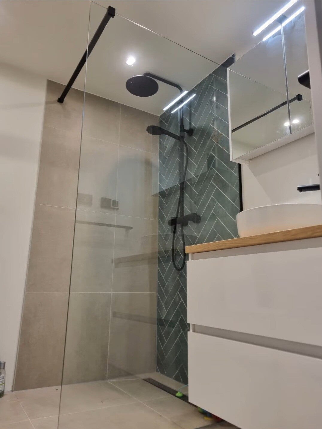Badkamer met regendouche en visgraat-tegelwand