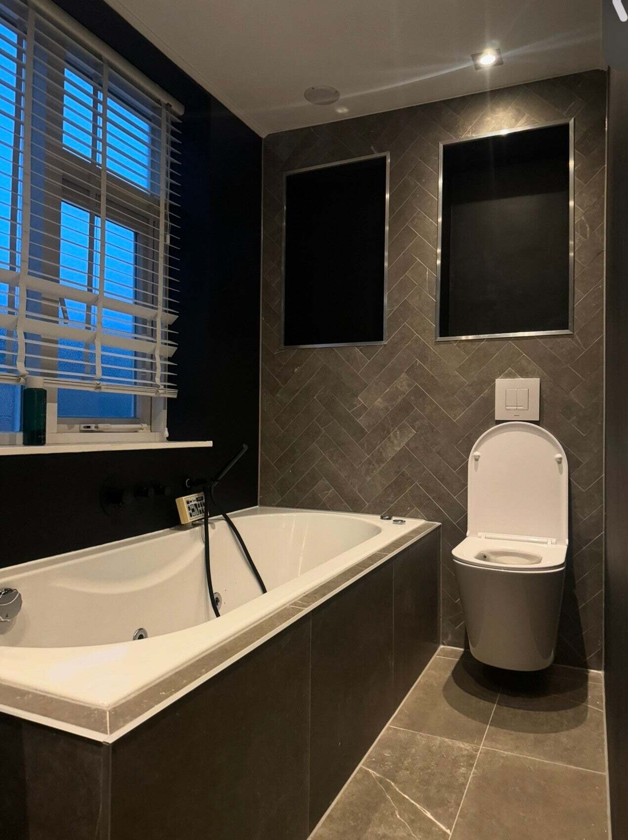 Badkamer met inbouwbad en tegelnissen