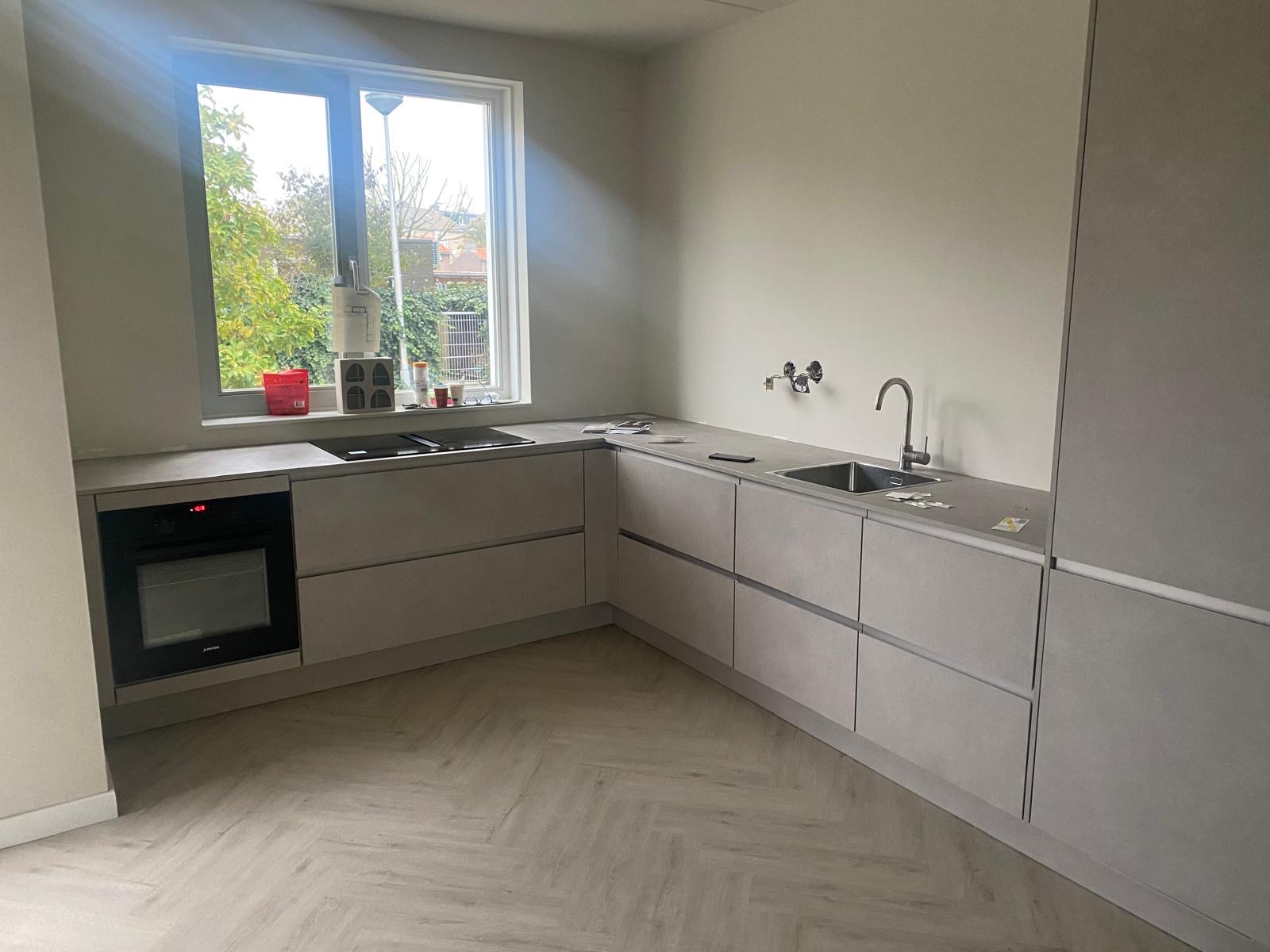 Wit keukeneiland met inbouwapparatuur in aanbouw